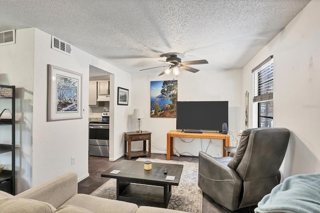 living room featuring dark hardwood / wood-style flooring, a textured ceiling, and ceiling fan