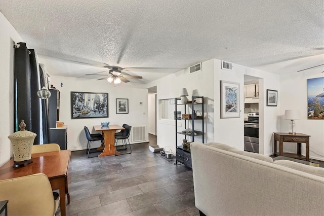 living room with a textured ceiling and ceiling fan