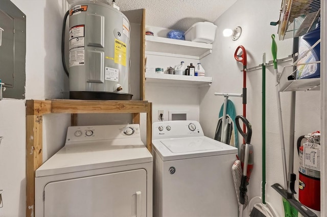 clothes washing area featuring water heater, washer and dryer, and a textured ceiling