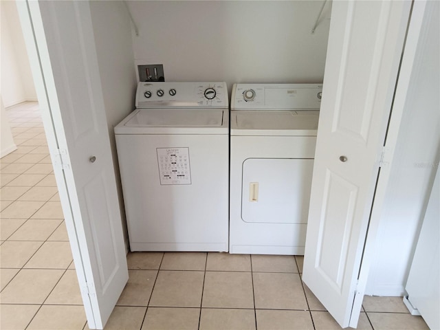 washroom with washer and clothes dryer, laundry area, and light tile patterned floors