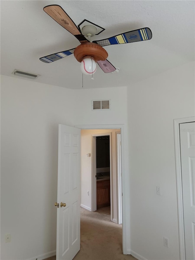 unfurnished bedroom with visible vents, baseboards, light colored carpet, and ceiling fan