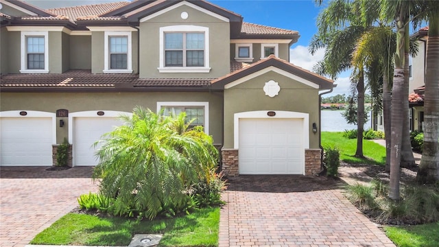 view of front of property with a tile roof, decorative driveway, and stucco siding