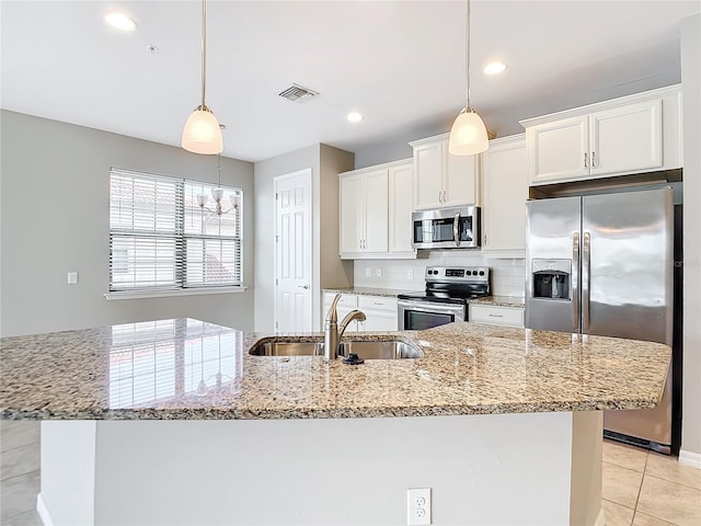 kitchen featuring visible vents, white cabinets, appliances with stainless steel finishes, light stone countertops, and a sink