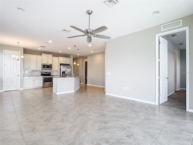 kitchen featuring stainless steel appliances, open floor plan, visible vents, and a ceiling fan