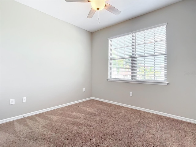 empty room featuring a ceiling fan, carpet, and baseboards