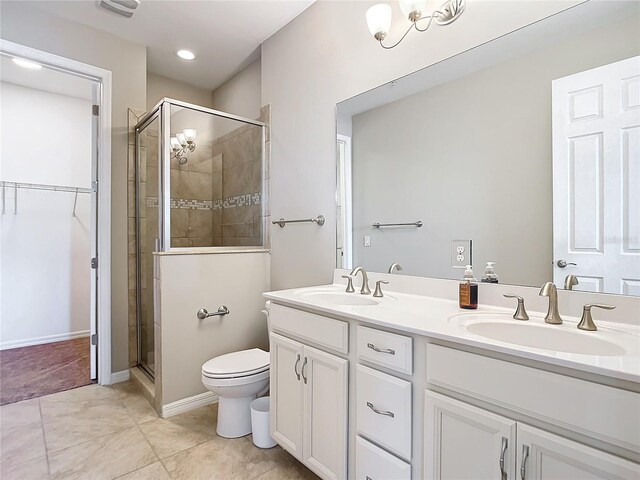 bathroom with double vanity, toilet, tile patterned flooring, and a shower with shower door