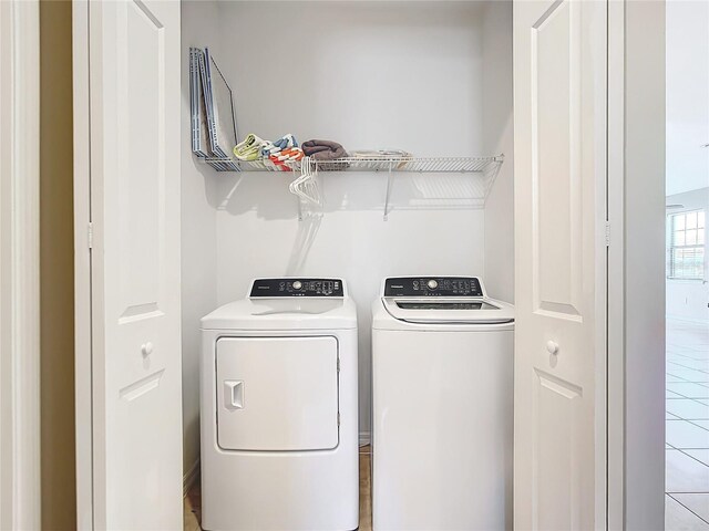 washroom with light tile patterned floors and washing machine and dryer