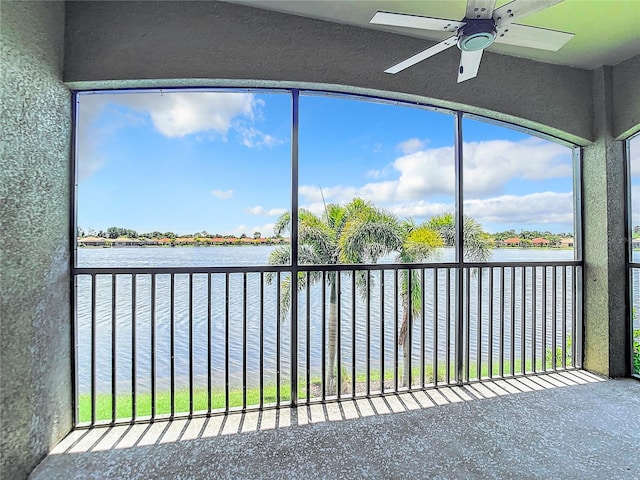 unfurnished sunroom with a water view and ceiling fan