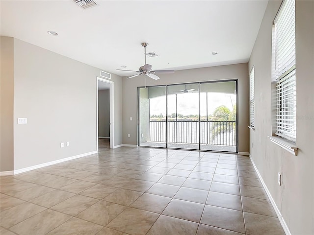 spare room with ceiling fan and light tile patterned flooring