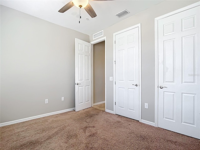 unfurnished bedroom featuring light colored carpet, visible vents, ceiling fan, and baseboards