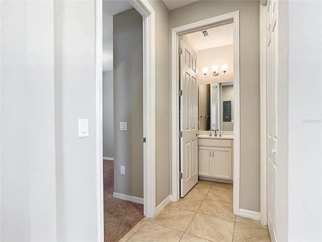 corridor featuring light tile patterned floors and sink