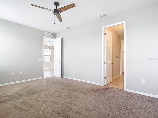 unfurnished bedroom featuring light colored carpet, visible vents, and baseboards