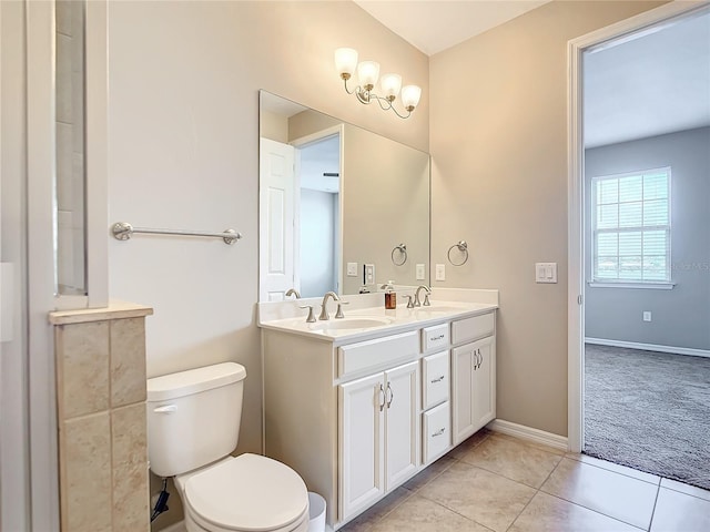 bathroom featuring double vanity, tile patterned flooring, a sink, and toilet