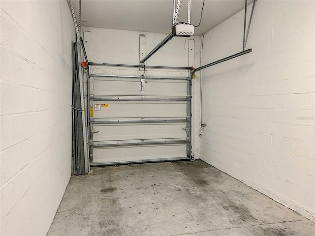 garage with a garage door opener and concrete block wall