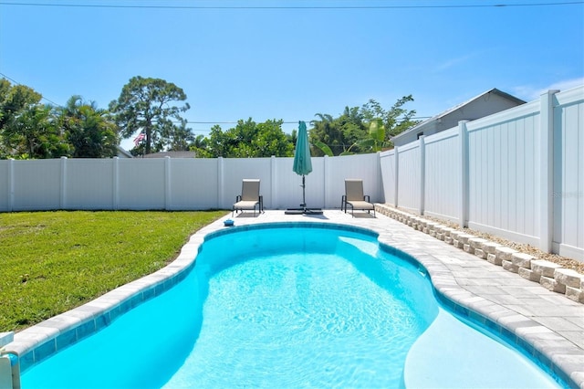 view of swimming pool with a lawn