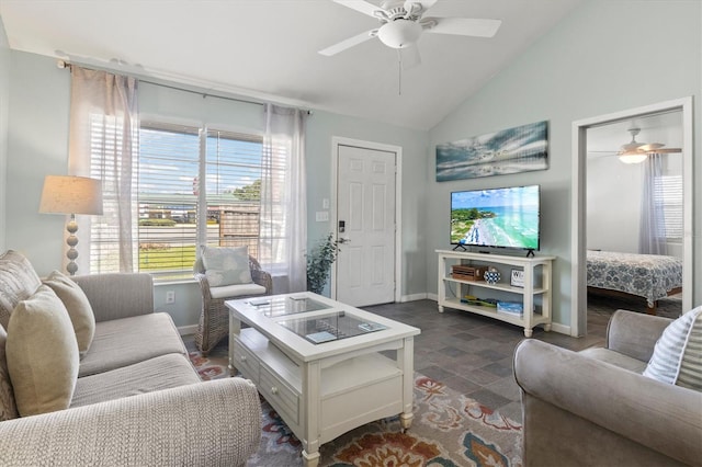 living room featuring ceiling fan, dark tile patterned flooring, and lofted ceiling