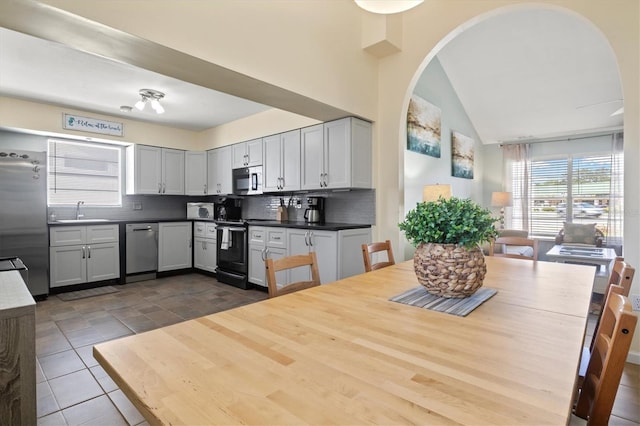 kitchen featuring gray cabinets, tile patterned floors, stainless steel appliances, sink, and decorative backsplash