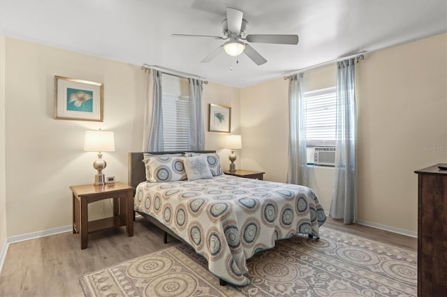 bedroom with ceiling fan, light hardwood / wood-style flooring, and cooling unit