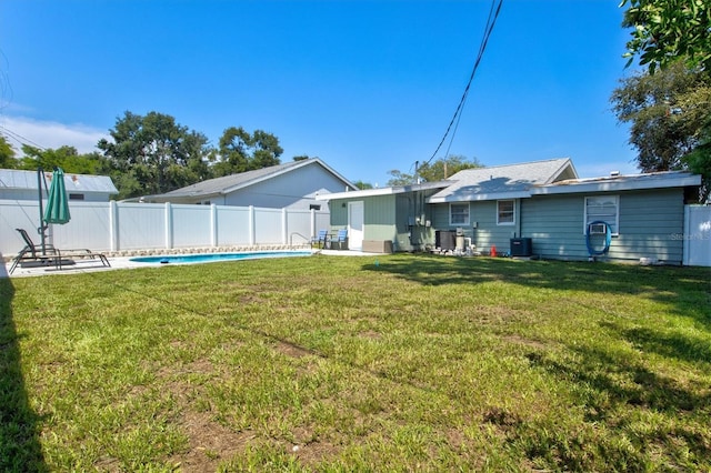 rear view of property with a fenced in pool, a yard, and central AC unit