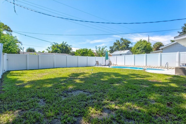 view of yard featuring central air condition unit and a fenced in pool