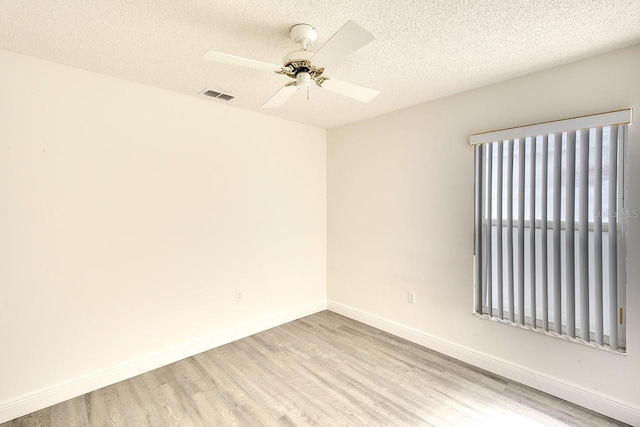 spare room featuring ceiling fan, a textured ceiling, and light hardwood / wood-style flooring