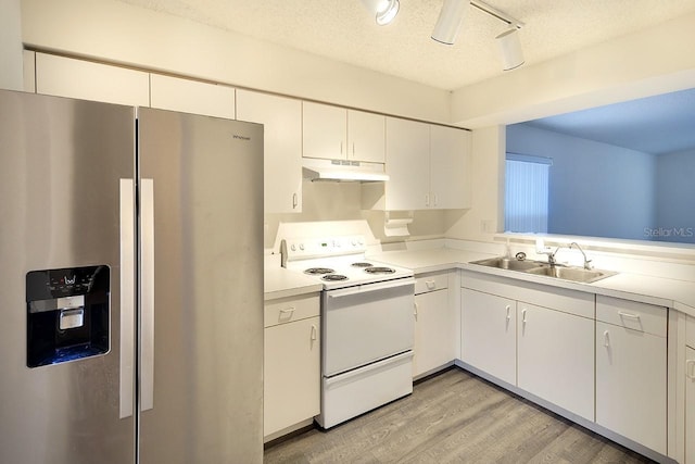 kitchen with stainless steel fridge, light countertops, white electric range, under cabinet range hood, and a sink