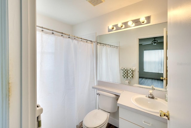 bathroom featuring toilet, vanity, and ceiling fan