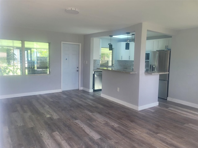 kitchen with white cabinets, dark wood-type flooring, backsplash, and appliances with stainless steel finishes