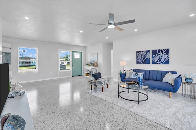 living room with ceiling fan and a wall mounted AC