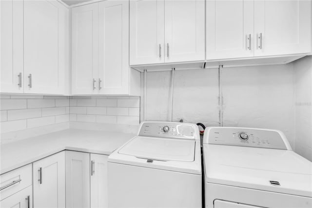 clothes washing area featuring cabinets and independent washer and dryer