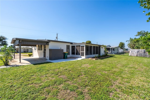 back of house featuring a sunroom, a lawn, and a patio area