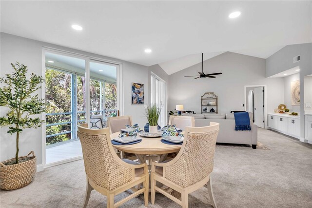 carpeted dining area featuring vaulted ceiling and ceiling fan