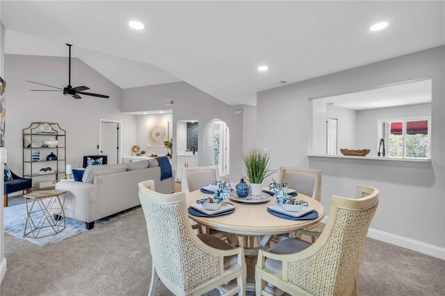 carpeted dining space featuring ceiling fan and lofted ceiling