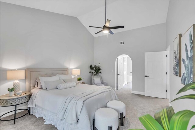 carpeted bedroom with ceiling fan and high vaulted ceiling