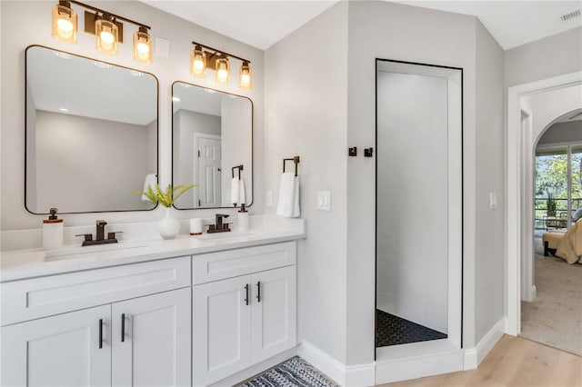 bathroom featuring vanity, hardwood / wood-style floors, and a shower