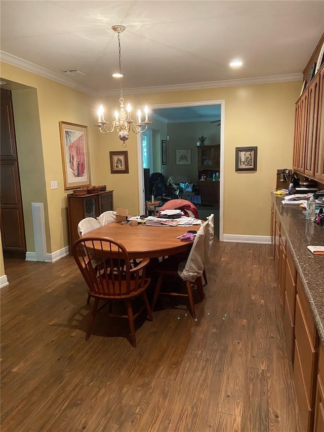 dining area featuring dark wood-type flooring, crown molding, and an inviting chandelier