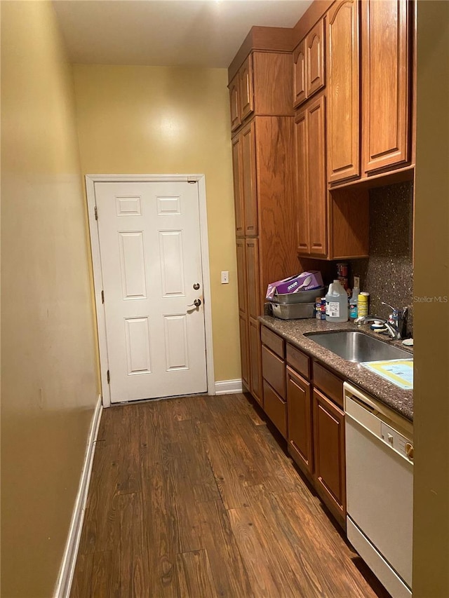 kitchen featuring sink, dark wood-type flooring, white dishwasher, and backsplash