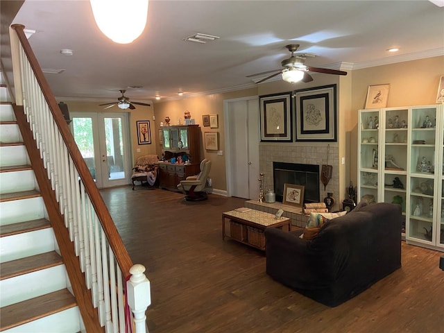 living room with ceiling fan, dark hardwood / wood-style flooring, a fireplace, and ornamental molding