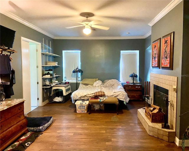 living room featuring ceiling fan, crown molding, a fireplace, and wood-type flooring