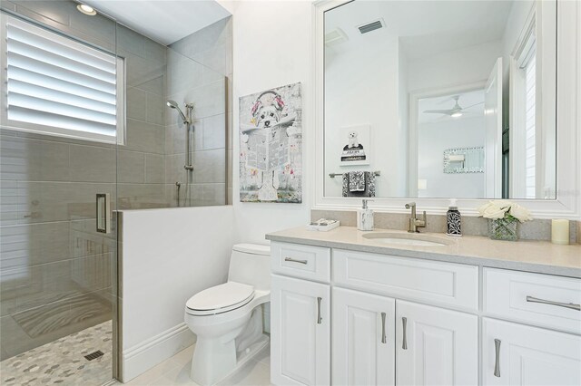 bathroom with ceiling fan, a shower with door, toilet, tile patterned flooring, and vanity