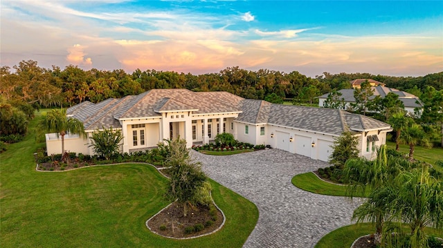 mediterranean / spanish home with a lawn and a garage