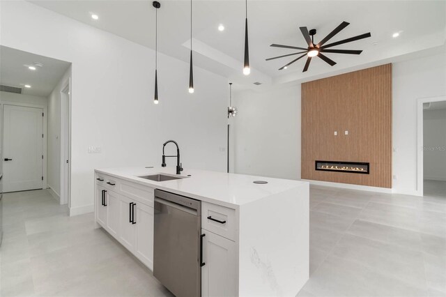 kitchen with a fireplace, stainless steel dishwasher, white cabinetry, ceiling fan, and sink