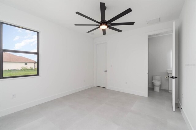 unfurnished bedroom with ceiling fan, light tile patterned flooring, and connected bathroom