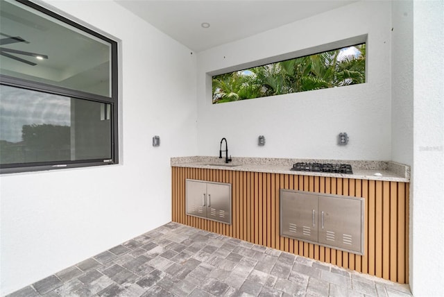 bar with tile patterned floors, sink, and black gas cooktop