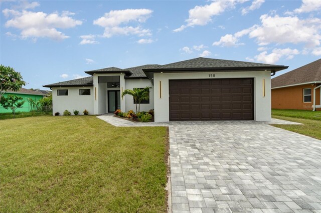 prairie-style house featuring a garage and a front yard