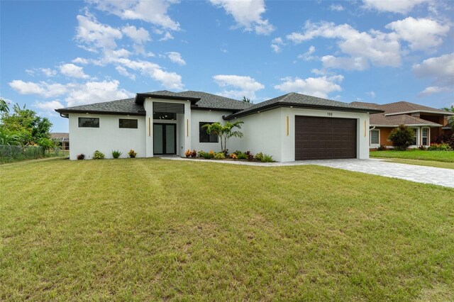 prairie-style home featuring a garage and a front lawn