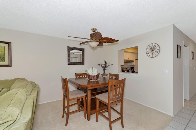 tiled dining space with a textured ceiling and ceiling fan