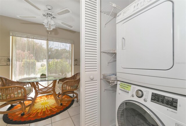 laundry area with stacked washing maching and dryer, light tile patterned floors, and ceiling fan