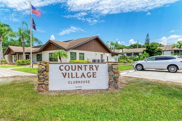 community / neighborhood sign featuring a lawn