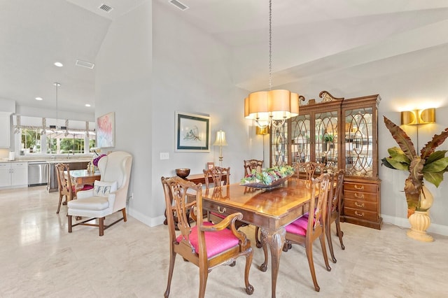 tiled dining area with a notable chandelier and high vaulted ceiling